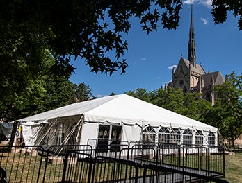 fenced-in line leads to white tent, Heinz Memorial Chapel in background
