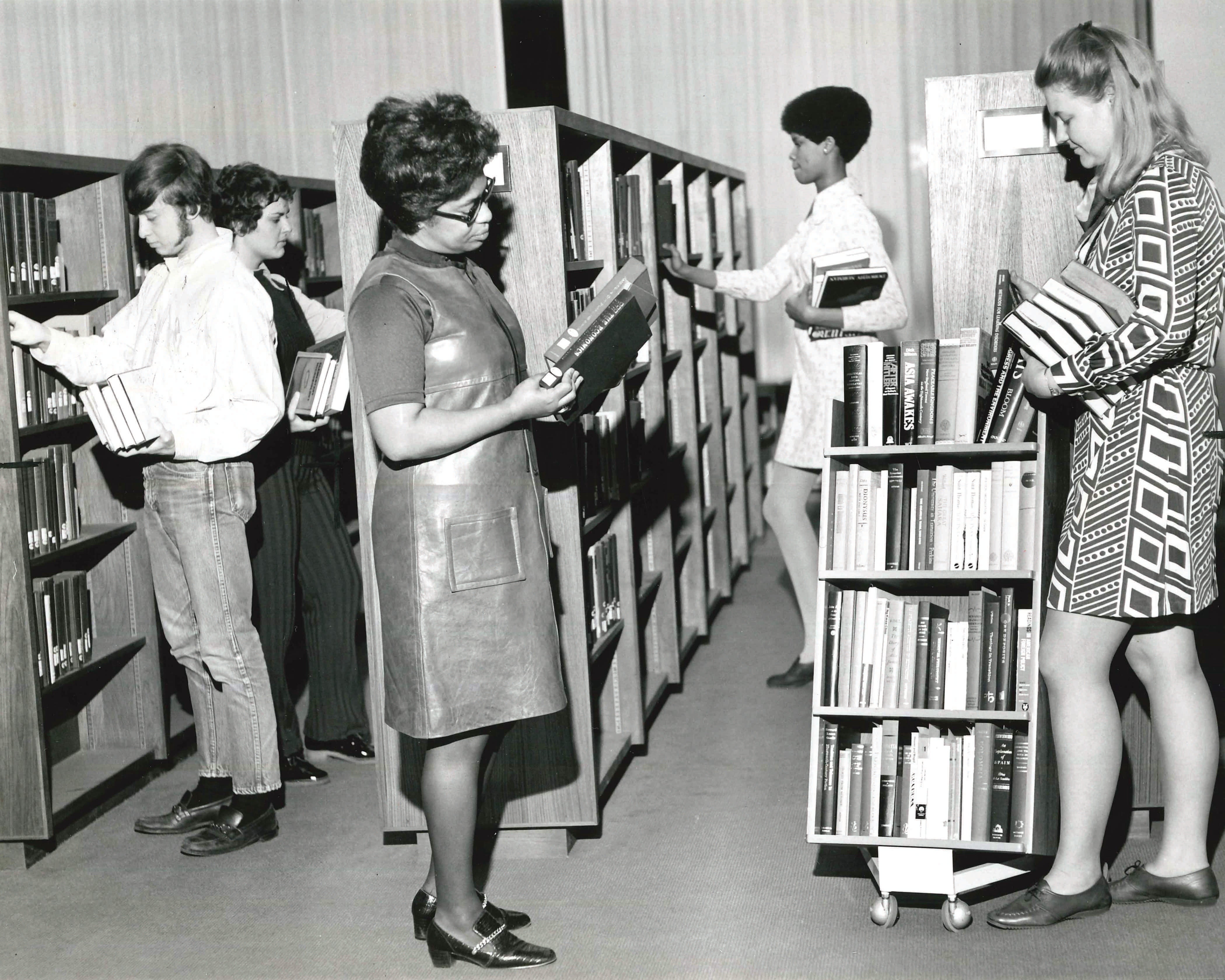 Librarians and work study students shelve newly acquired books in November 1970.